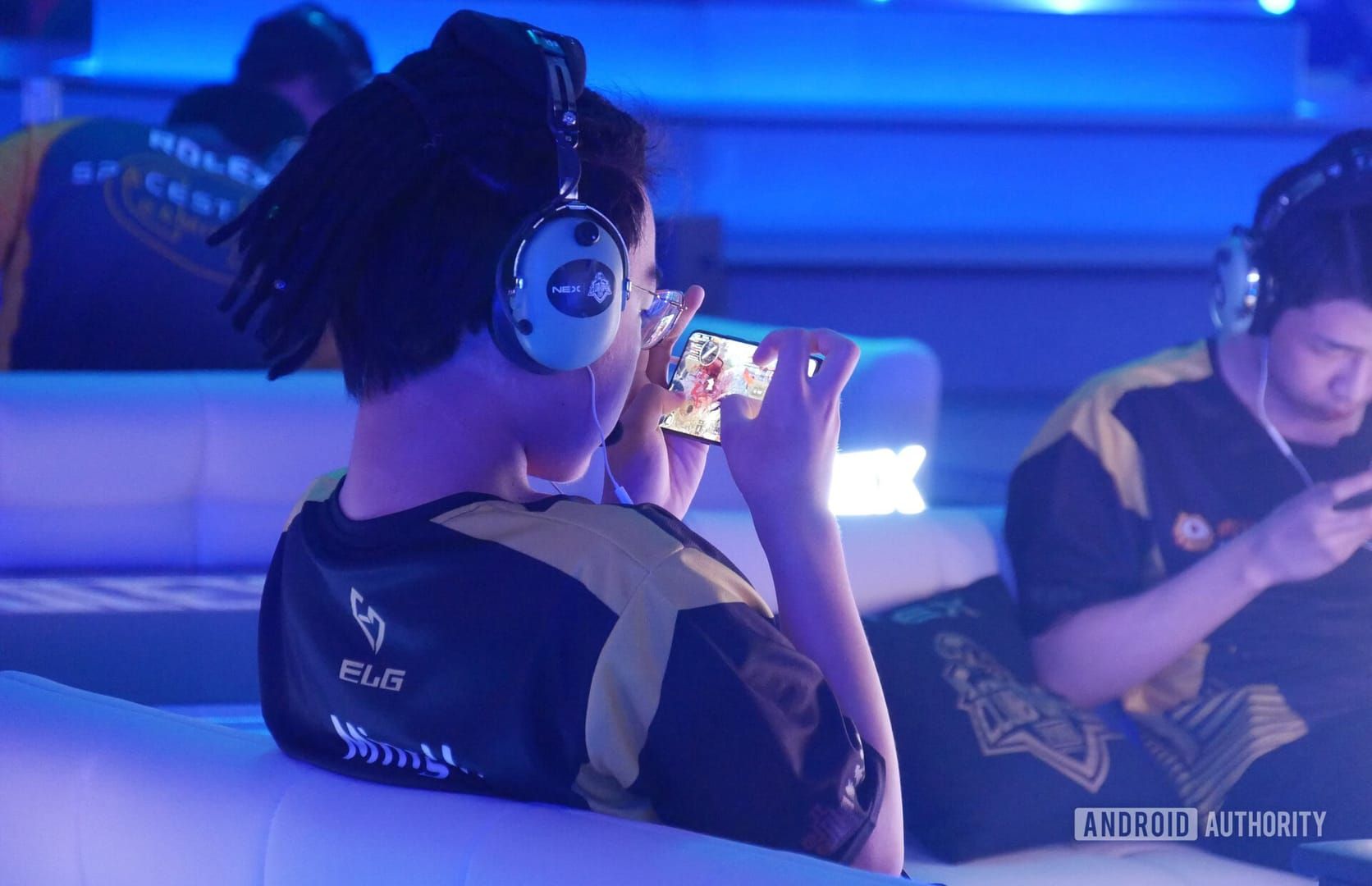 Professional PUBG Mobile tournament setup showing players using approved smartphone devices